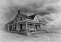 Old black and white abandoned spooky looking house in winter on a farm yard in rural Canada