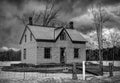 Old black and white abandoned spooky looking farmhouse in winter on a farm yard in rural Canada Royalty Free Stock Photo