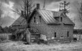 Old black and white abandoned spooky looking farmhouse in winter on a farm yard in rural Canada Royalty Free Stock Photo