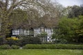 An old black and white building partly hidden by trees in Peterborough, Cambridgeshire Royalty Free Stock Photo