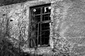 Old black and white damaged wall with a barred window Royalty Free Stock Photo