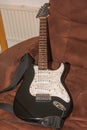 Old black white electric guitar on the armchair Royalty Free Stock Photo