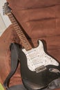 Old black white electric guitar on the armchair Royalty Free Stock Photo