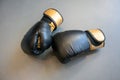 Old black and yellow boxing gloves on grey concrete background Royalty Free Stock Photo