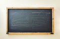 Old blackboard with wooden frame hangs on wall in classroom. Board surface with white chalk marks after challenging Royalty Free Stock Photo