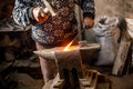 Old blacksmith manually forging molten metal with hammer on the anvil Royalty Free Stock Photo