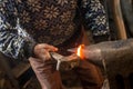 Old blacksmith manually forging molten metal with hammer on the anvil Royalty Free Stock Photo