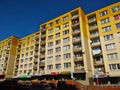 Old block of flats with reconstructed facade of yellow color going down with gradient into beige