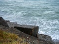 Old blocks of fortifications of the coast. Concrete structures on the shore. Protection against storms, wave movement