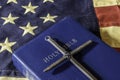 Old blue bible and cross on American flag