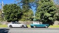 An old blue car and a new white car were parked next to the courtyard gate. Contrast old and new