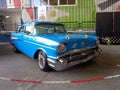 Old blue 1957 Chevrolet Chevy Bel Air sport sedan two-door on colorful background. Classic car show