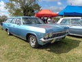 Old 1965 Chevrolet Impala estate station wagon on the lawn. Nature, grass, trees. Classic car show