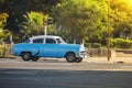 Old blue classic American car stands at an intersection in front of a traffic light Royalty Free Stock Photo