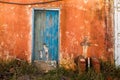 Old blue colored door in abandoned orange house Royalty Free Stock Photo