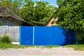 An old blue corrugated metal gate in front of an old apartment building. Royalty Free Stock Photo