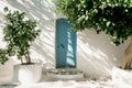 Old blue door with green trees on Santorini island, Greece Royalty Free Stock Photo