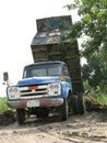 Old blue dump truck is dumping soil Royalty Free Stock Photo