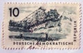 An old blue east german postage stamp with image of railway wagons and a mining activity