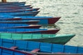 Old blue empty wooden boats on the water at the pier in a row against the blurred background of boats Royalty Free Stock Photo