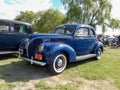 Old blue 1938 Ford V8 Deluxe coupe on the lawn