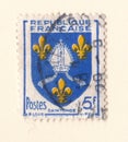 An old blue french postage stamp with an image of a mitre and crest