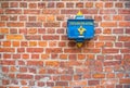 An old blue German mailbox hanging on a brick wall