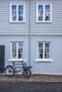 Old blue house with windows and a bicycle.