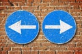 Old blue metallic arrow sign against an aged brick wall indicating to go left and right - concept image Royalty Free Stock Photo
