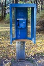 Old blue payphone in a booth on the street Royalty Free Stock Photo