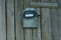 Old blue plywood mailbox hanging on gray wooden planks Royalty Free Stock Photo