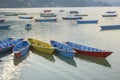 A old blue red yellow green wooden boats on the water of the lake against the backdrop of the mountains. colorful boats without Royalty Free Stock Photo