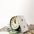 An old blue ruined analog clock that shows five minutes to twelve o`clock. The watch is on US dollar bills, and next to it is a Royalty Free Stock Photo