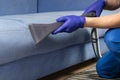 The old blue sofa is cleaned with a vacuum cleaner, with a wet cleaning function to restore the perfect look