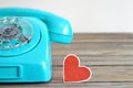 Old blue telephone and heart shaped tag Royalty Free Stock Photo