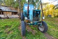 An old blue tractor stands in a farmyard Royalty Free Stock Photo