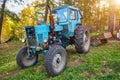 An old blue tractor stands in a farmyard Royalty Free Stock Photo