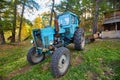 An old blue tractor stands in a farmyard Royalty Free Stock Photo
