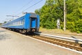 Old blue train is leaving the platfrom at the railway station