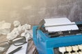 An old blue typewriter and trash paper on wooden desk. Copy space Royalty Free Stock Photo