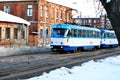 Old blue and white tram in old city streets, railroad along low storey apartment buildings in Grekovskaya street