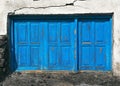 Old blue window with three closed shutters of old house. Facade detail, doors and windows.