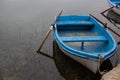 Old blue wooden boat moored at the edge of a lake Royalty Free Stock Photo