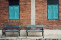 Old blue wooden chair with vintage red brick wall and blue window. Vintage background