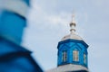 an old, blue, wooden church with a silver dome