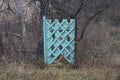 Old blue wooden door and gray fence made of metal mesh Royalty Free Stock Photo