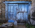 Old blue wooden door in a stone wall, rural scene