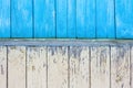 An old blue and yellow wooden wall of a house with cracked peeling oil paint. Royalty Free Stock Photo