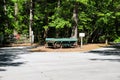 An old bluish green wooden wagon with rusty wheels surrounded by lush green trees at Newman Wetlands Center