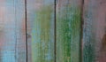 Old boards with cracked paint, peeling and cracks, randomly painted in delicate colors: pink, yellow, blue, green Royalty Free Stock Photo